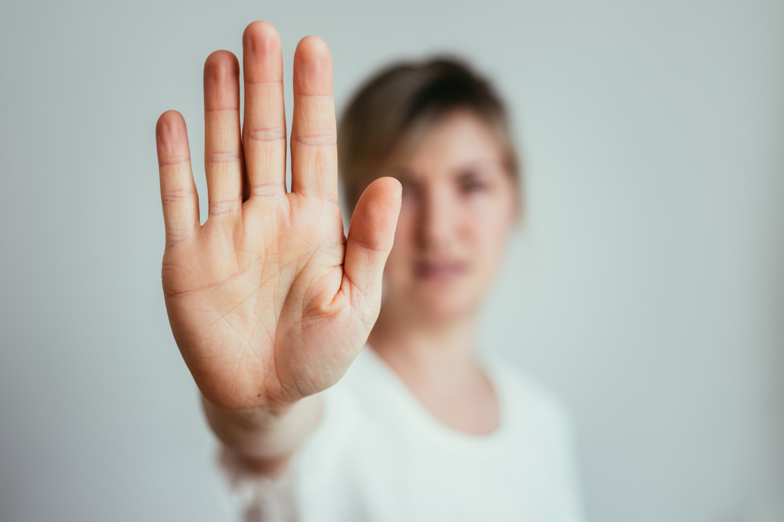 Junge Frau hebt die Hand und signalisiert "Stopp". Kurtz Detektei Hannover.